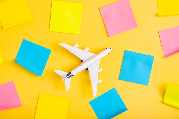 Foto composição plana de viagem no avião de fundo amarelo com papéis de nota em branco conceito de preparação de viagem