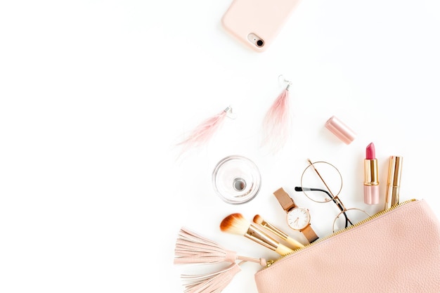 Composição plana leiga com bolsa cosmética rosa com produtos de maquiagem cosméticos isolados em backgrou branco
