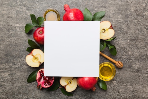 Composição plana leiga com cartaz de folheto em branco e símbolos judaicos atributos de feriado de Rosh Hashaná em fundo colorido Feriado de ano novo Vista superior tradicional com espaço de cópia mock up