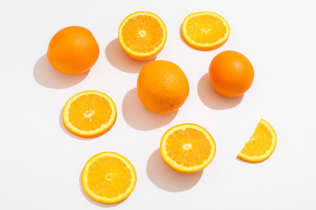 Composição plana leiga com laranjas em fundo branco, espaço para texto