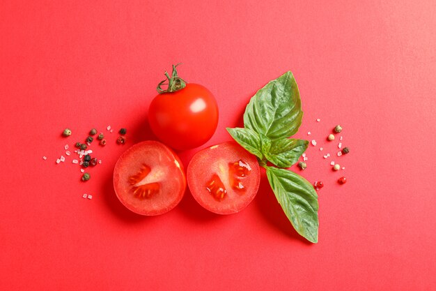 Composição plana leiga com tomate cereja fresco, manjericão e pimenta no espaço de cor, espaço para texto. Legumes maduros