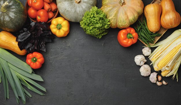 Composição vegetal de outono com abóbora, milho e pimenta em fundo preto