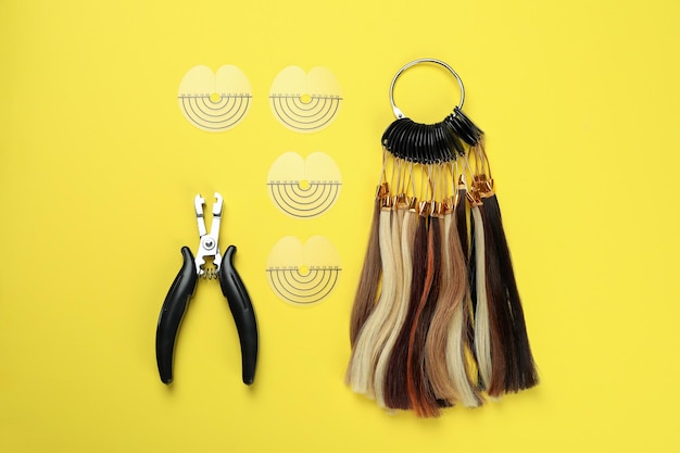 Composición con accesorios de extensión de cabello sobre fondo amarillo.