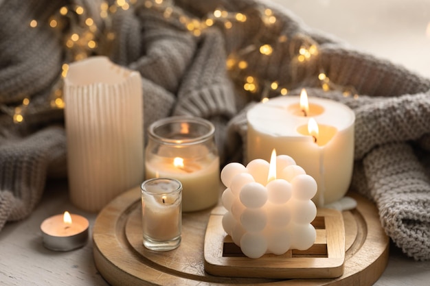Una composición acogedora con velas un elemento tejido y una guirnalda