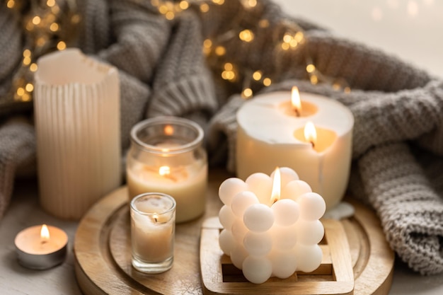 Una composición acogedora con velas un elemento tejido y una guirnalda