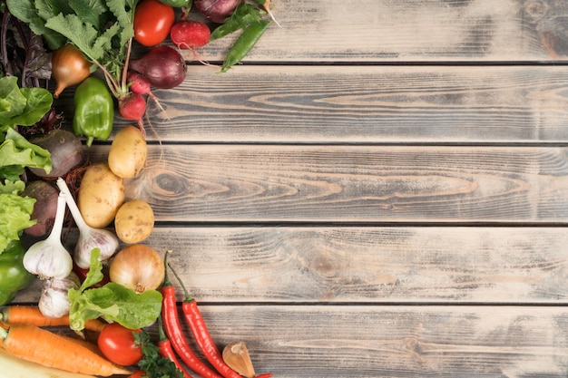 Foto composición de alimentos de cosecha propia colorida y sabrosa de una variedad de verduras de granja orgánicas saludables sobre fondo de madera vista superior