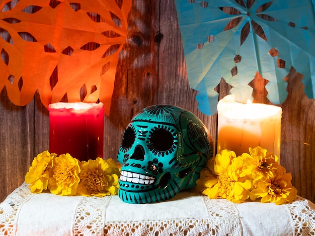 Composición del altar tradicional para el día de muertos mexicano con ofrenda de velas de calavera y flores.