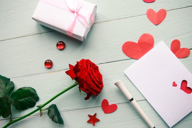 Composición de amor caja de regalo de rosa roja y tarjeta de felicitación en fondo de madera vista superior concepto de boda o San Valentín