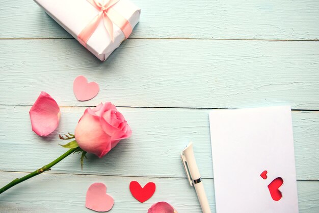 Composición de amor caja de regalo de rosa rosa y tarjeta de felicitación en fondo de madera vista superior concepto de boda o de San Valentín