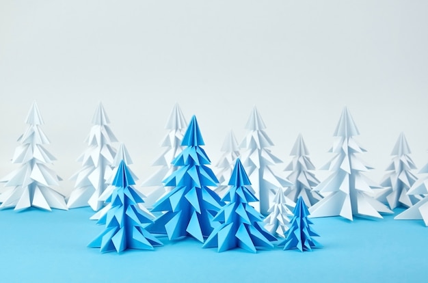 Composición de árboles de Navidad de origami de papel blanco y azul