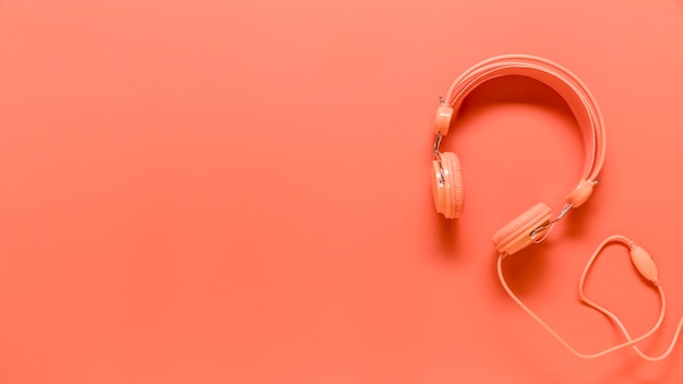 Foto composición de los auriculares rosa con cable usb.