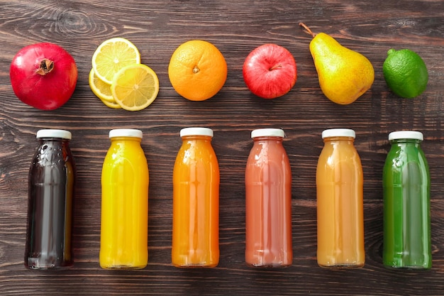 Composición con botellas de jugos de frutas e ingredientes en la mesa.