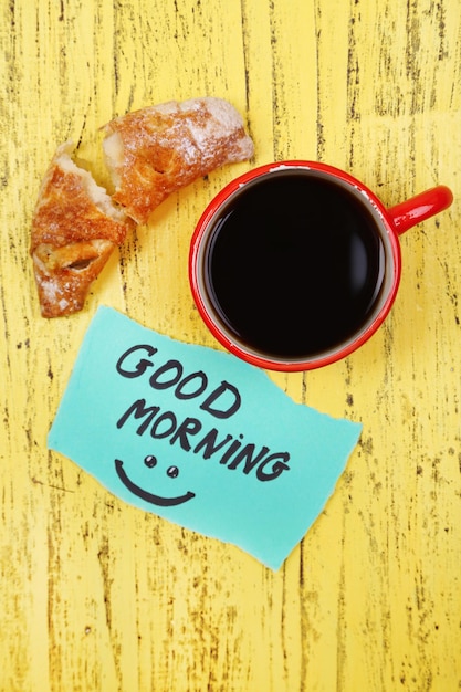 Foto composición de café croissant recién hecho y tarjeta de papel sobre fondo de madera