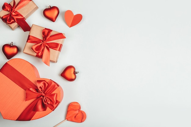 Composición con caja de regalo en forma de corazón, caramelos y corazón de papel en azul. Fondo con espacio de copia para el día de San Valentín.