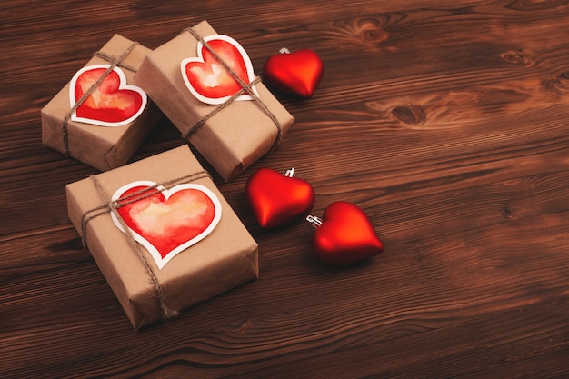 Composición con cajas de regalo y corazones de cristal sobre mesa de madera. Día de San Valentín.