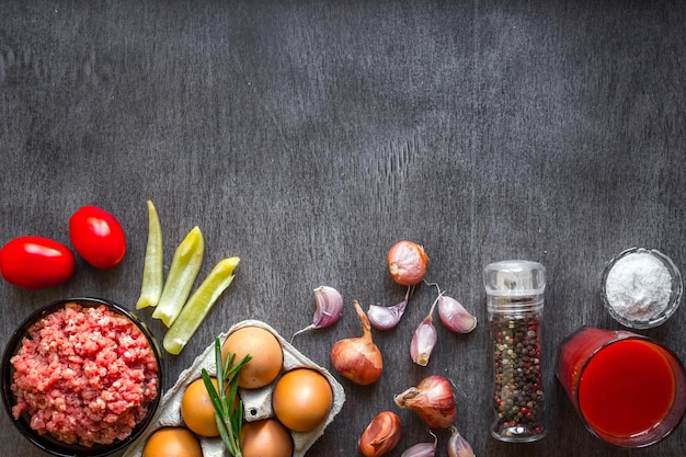 Composición de carne cruda con verduras y especias sobre fondo de madera