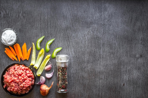 Composición de carne cruda con verduras y especias sobre fondo de madera