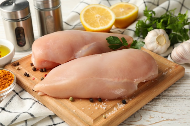 Composición con carne de pollo cruda en el espacio de madera, de cerca