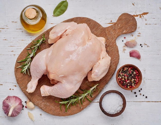 La composición de la carne de pollo cruda y fresca servida con varios ingredientes como el ajo