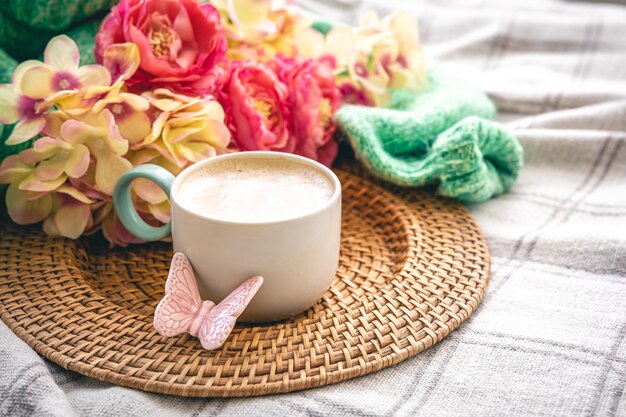 Composición casera con una taza de flores de café y un elemento de punto.