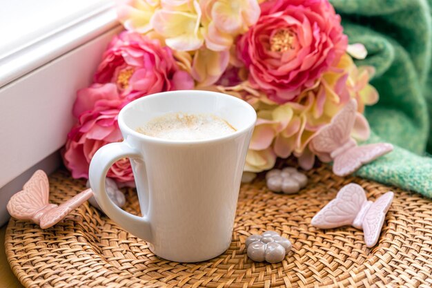 Composición casera con una taza de flores de café y un elemento de punto.