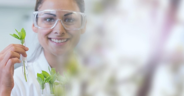 Composición de la científica sonriente sosteniendo el tubo de ensayo con planta y espacio de copia