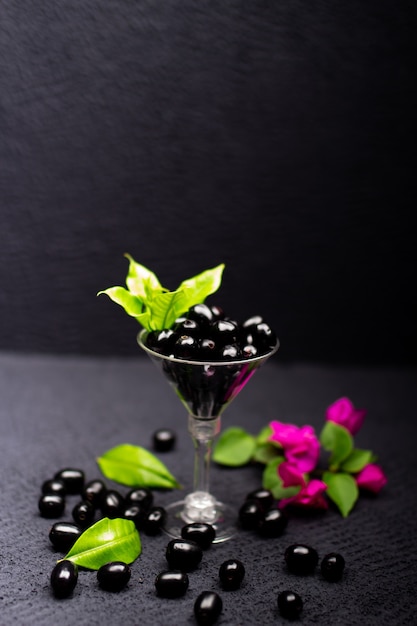 Composición de ciruela negra fresca con flores.