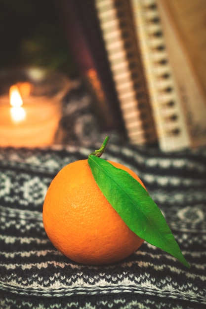 Composición de cítricos, composición de naturaleza muerta acogedora de invierno y otoño con mandarinas o mandarinas, fondo de libros. Foto de alta calidad