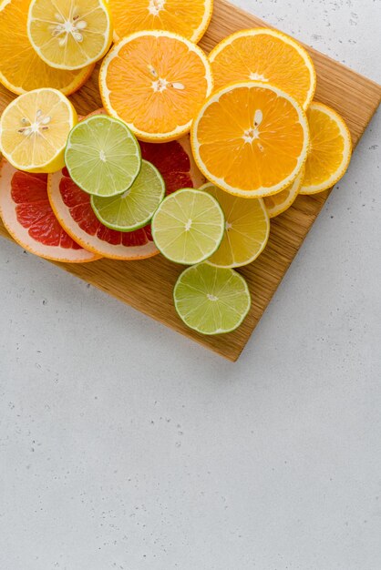 Composición de cítricos en la tabla de cortar muchos limones reducidos a la mitad limones pomelos espacio de copia vertical