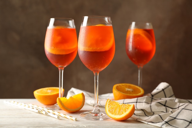 Foto composición con cóctel aperol spritz contra marrón.