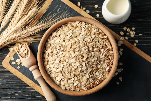 Composición con copos de avena y leche sobre madera.