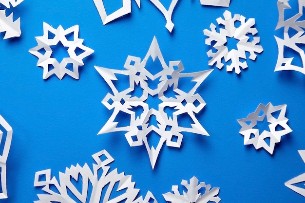 Composición con copos de nieve de papel en azul