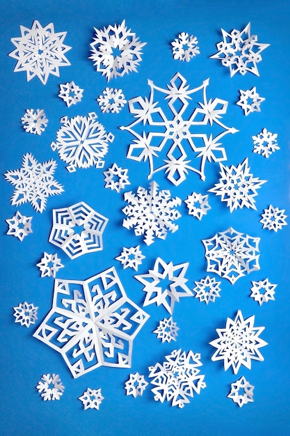 Composición con copos de nieve de papel en azul