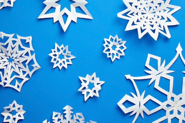 Composición con copos de nieve de papel en azul