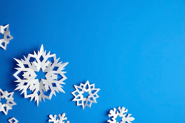 Composición con copos de nieve de papel en azul