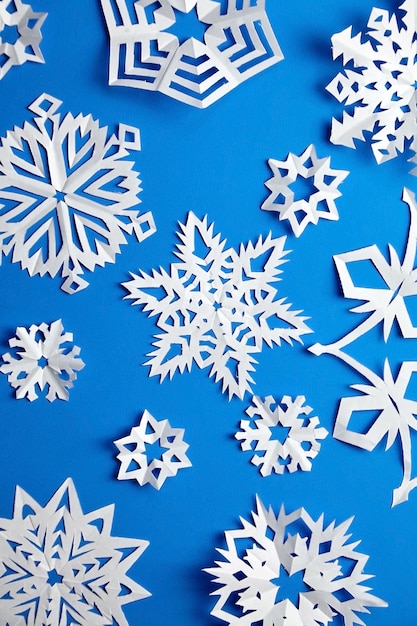 Composición con copos de nieve de papel en azul