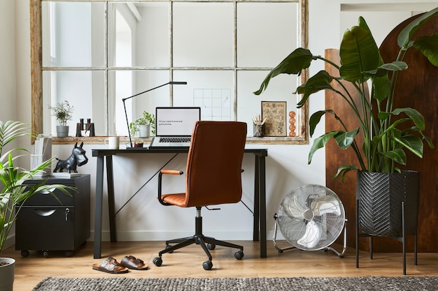 Composición creativa del diseño interior de la oficina en casa masculina moderna con escritorio industrial negro, sillón de cuero marrón, computadora portátil y elegantes accesorios personales. Plantilla.