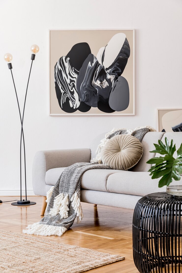 Composición creativa de diseño de interiores de sala de estar acogedor y elegante con marco, inodoro de madera, sofá y accesorios. Paredes blancas y suelo de parquet. Colores neutros.