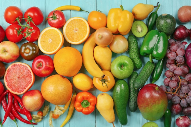 Composición creativa hecha de frutas y verduras en colores del arco iris en la superficie de madera, endecha plana