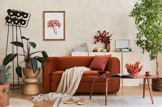 Composición creativa del interior de la elegante sala de estar con marco de póster simulado, sofá naranja, inodoro beige, mesa de centro y elegantes accesorios personales. Espacio artístico. Plantilla.