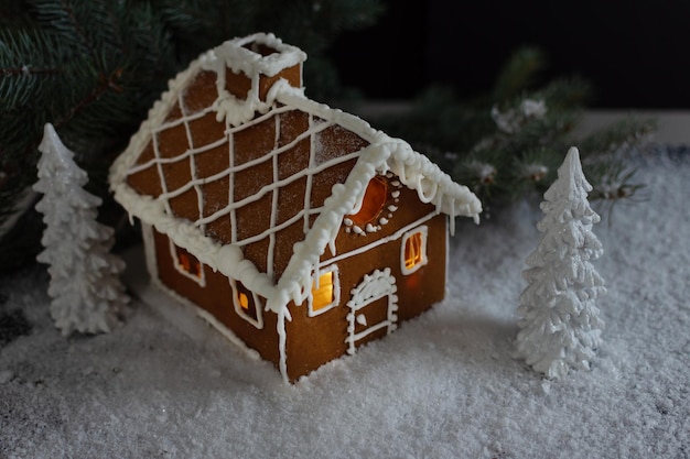 Composición creativa de invierno con casa de pan de jengibre hecha a mano.