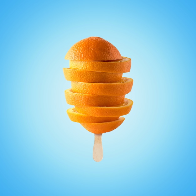 Composición creativa con rodajas de naranja en palito de helado