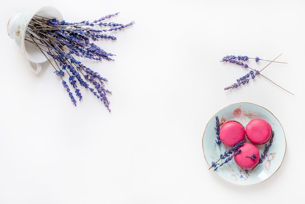 Composición creativa con taza, galletas macarons y flores de lavanda