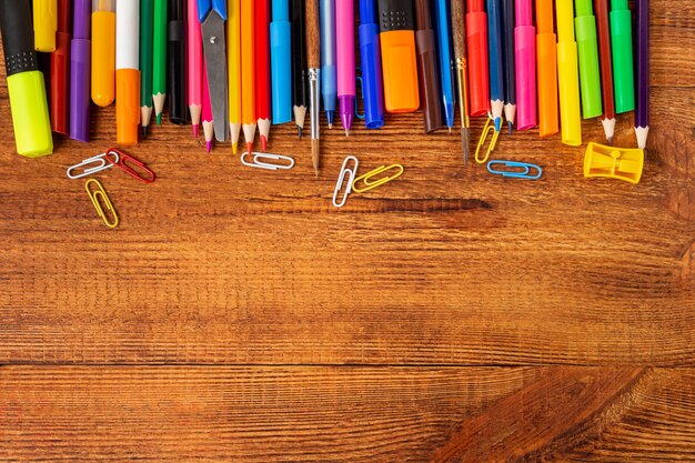 Composición con cuaderno en blanco página colorido lápiz, marcador y maqueta de pluma. De vuelta a la escuela