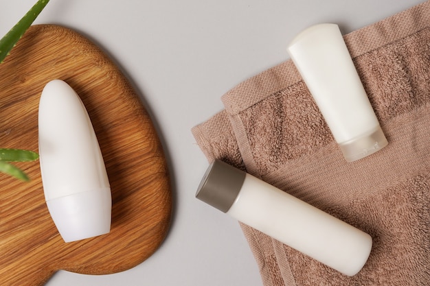 Composición para el cuidado de la piel desodorante y crema cosmética blanca sobre la toalla