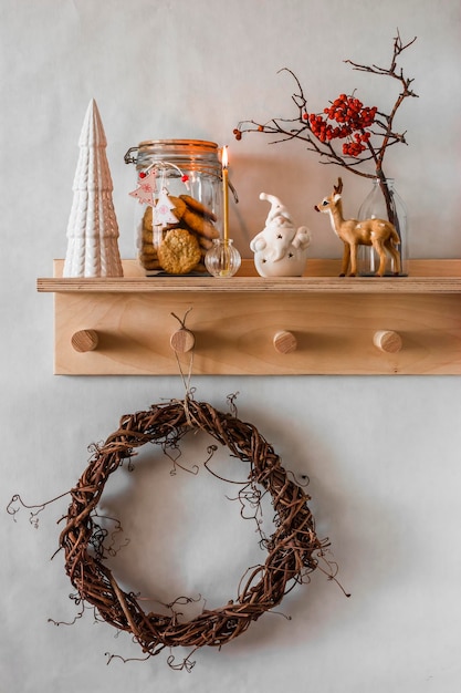 Composición de decoración navideña en un estante de madera en el interior de una habitación de estilo escandinavo