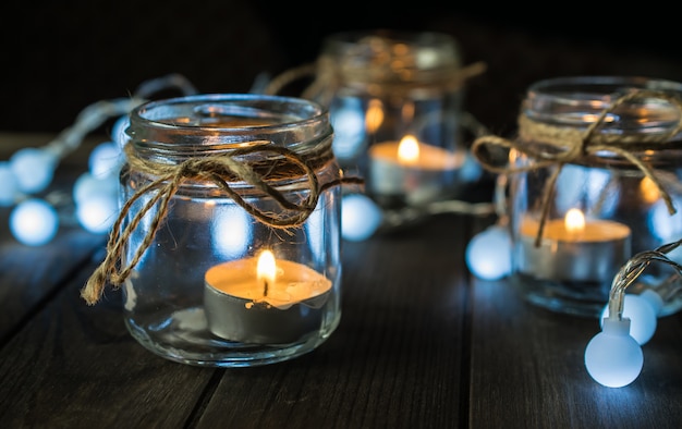 Composición decorativa con jarra de velas y luces.