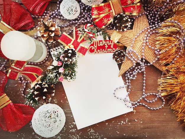 Composición decorativa de Navidad y año nuevo. Vista superior, fondo con espacio para copiar su texto. Estrella, conos, cuaderno, vela, arcos sobre una mesa de madera con nieve.