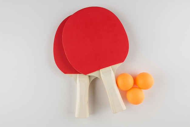 Composición deportiva Ping-pong cerca de raquetas y pelota para jugar en un fondo blanco