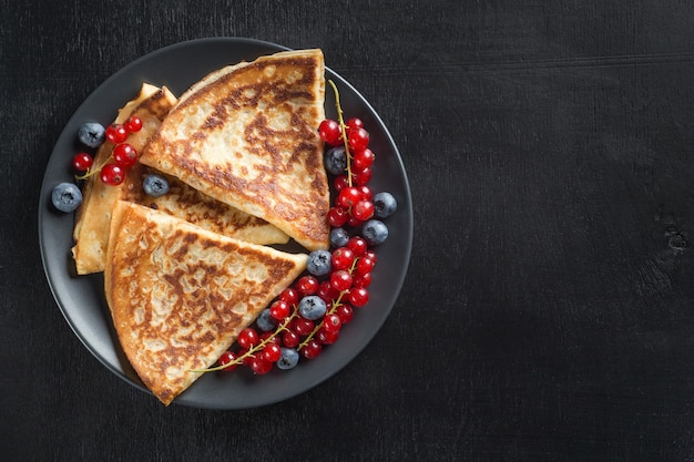 Composición del desayuno con panqueques frescos y bayas El concepto de alimentación saludable con espacio